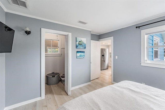 bedroom with light hardwood / wood-style floors, stainless steel fridge, and crown molding