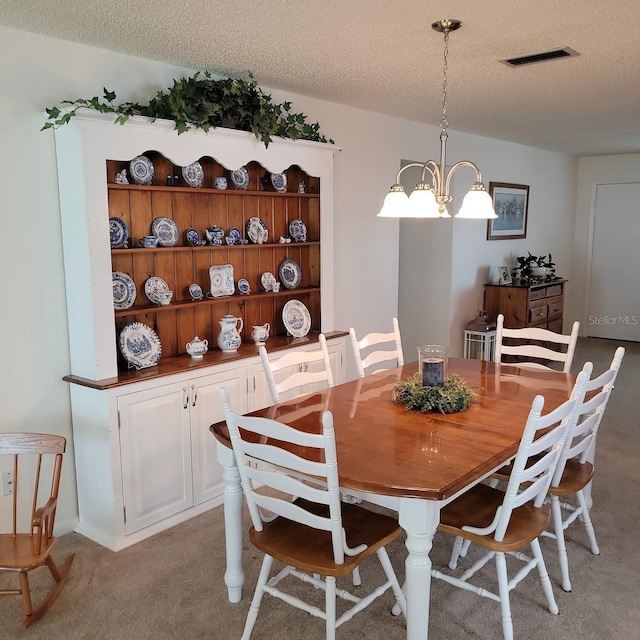 dining area with a textured ceiling, a chandelier, and light carpet