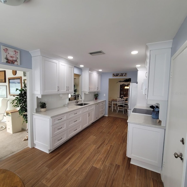 kitchen featuring white refrigerator, dark hardwood / wood-style flooring, sink, white cabinetry, and tasteful backsplash