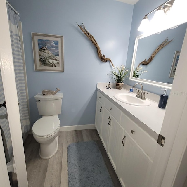 bathroom featuring toilet, wood-type flooring, and vanity