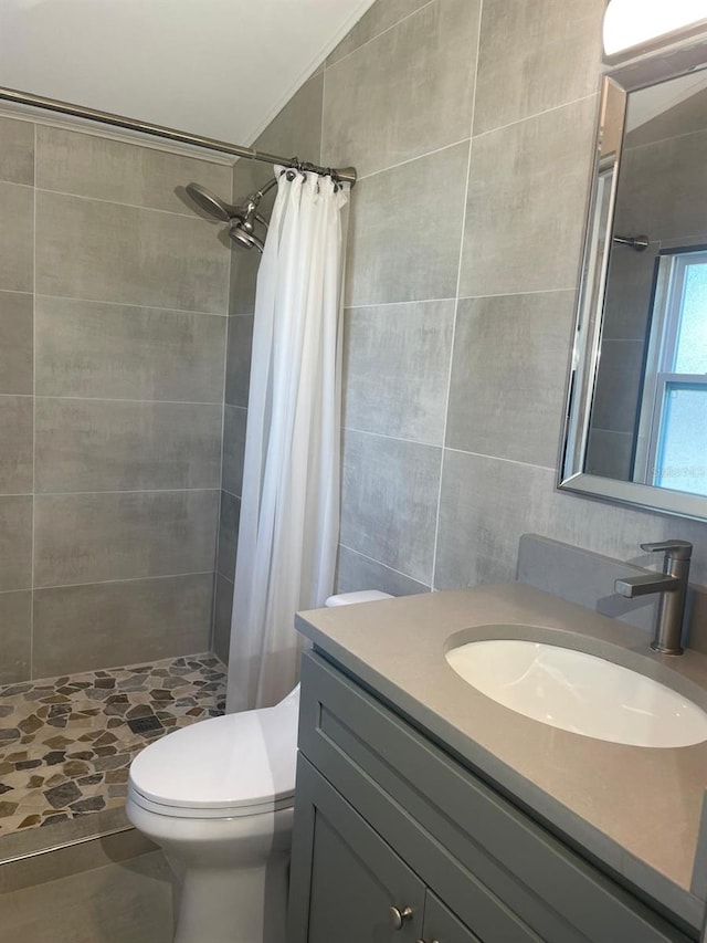 bathroom with a shower with shower curtain, vanity, toilet, and vaulted ceiling