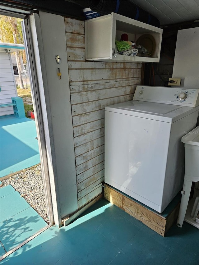 washroom featuring wood walls and washer / dryer