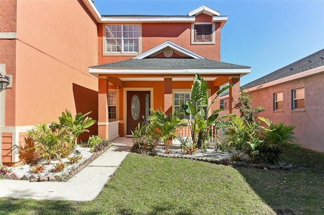 view of exterior entry featuring a lawn