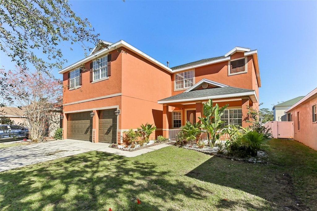 view of front of home with a garage, driveway, a front yard, and stucco siding