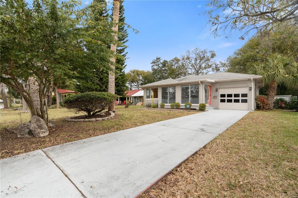 single story home featuring a front yard and a garage