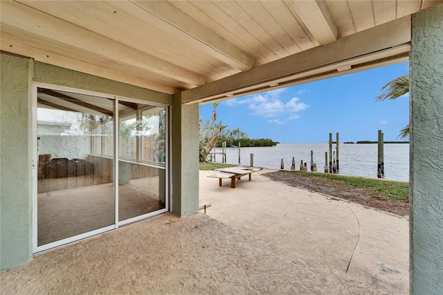 view of patio with a water view and a boat dock