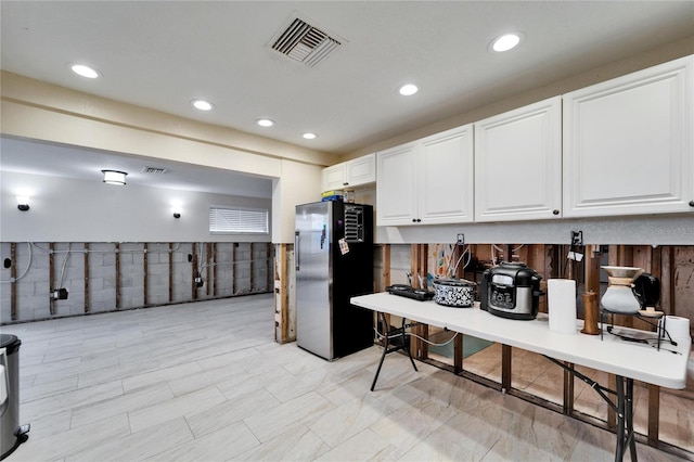 kitchen featuring white cabinets and stainless steel fridge