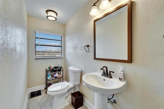 1022 Canal St, Ruskin, FL 33570 - bathroom featuring baseboards, toilet, and a textured wall