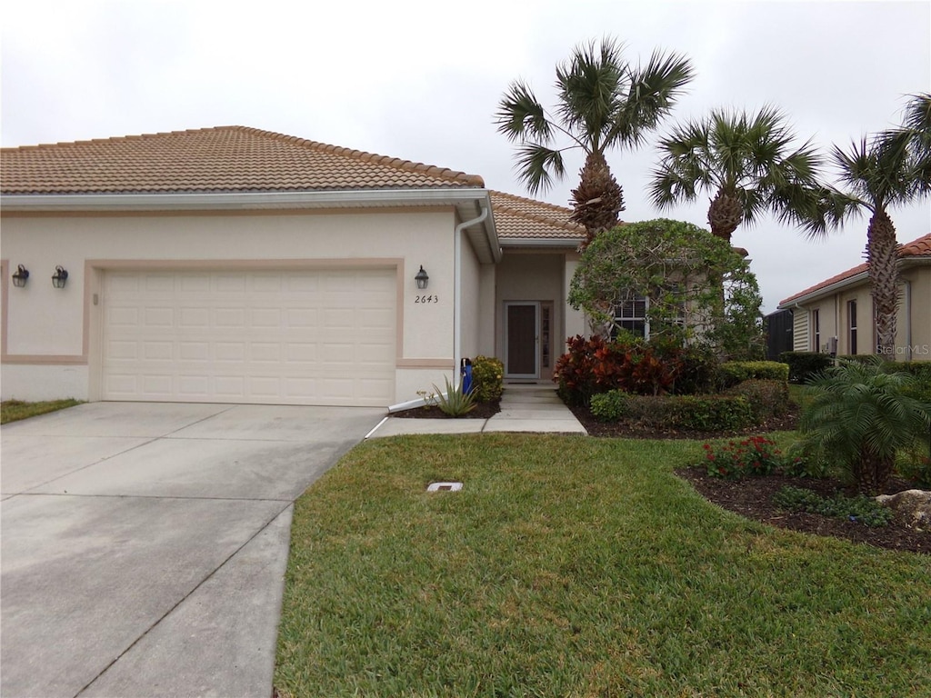 mediterranean / spanish house with a front lawn and a garage