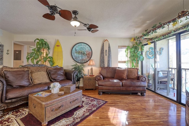 living room with hardwood / wood-style flooring, a textured ceiling, and ceiling fan