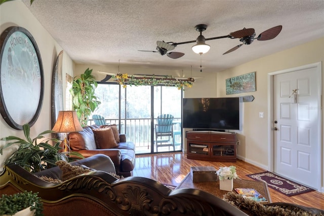 living room featuring a textured ceiling, ceiling fan, and wood-type flooring