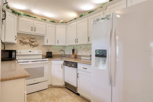 kitchen with sink, light tile patterned floors, white appliances, light stone countertops, and white cabinets