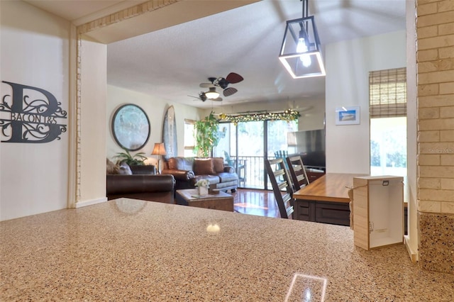 kitchen with ceiling fan, a fireplace, wood counters, and hanging light fixtures