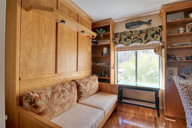 living area with a textured ceiling and hardwood / wood-style flooring