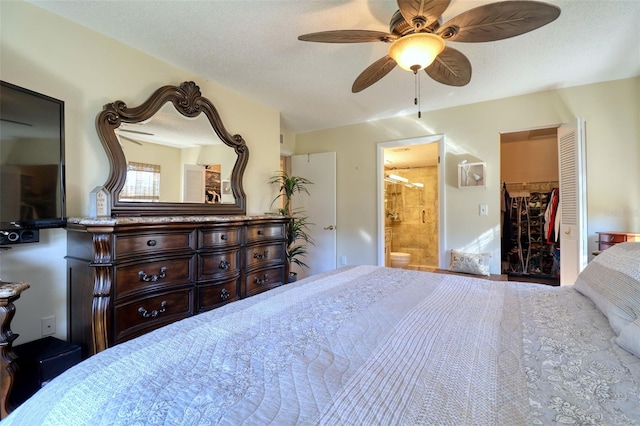 bedroom featuring ensuite bathroom, ceiling fan, a textured ceiling, a walk in closet, and a closet