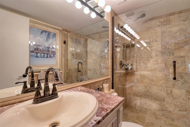 bathroom with a shower with shower door and vanity