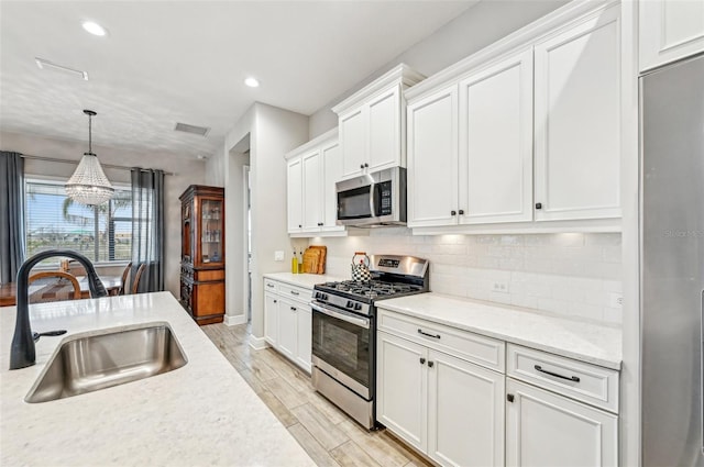 kitchen with white cabinetry, sink, and stainless steel appliances