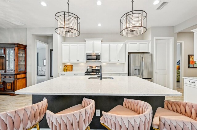 kitchen with pendant lighting, appliances with stainless steel finishes, and a chandelier