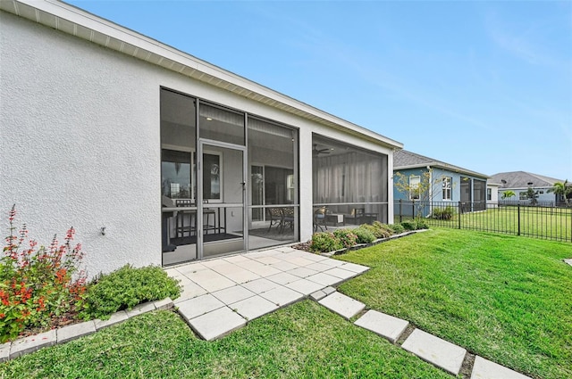 rear view of house with a yard and a sunroom