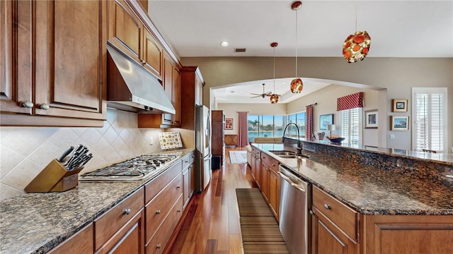 kitchen with sink, ceiling fan, an island with sink, decorative light fixtures, and stainless steel appliances