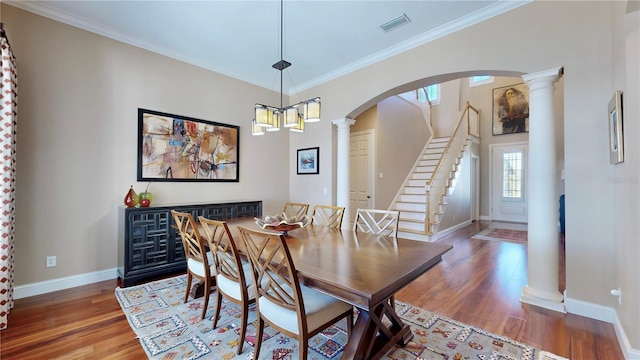 dining area with dark hardwood / wood-style floors, crown molding, and an inviting chandelier