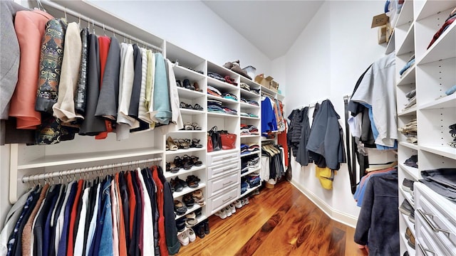 spacious closet with vaulted ceiling and dark hardwood / wood-style floors