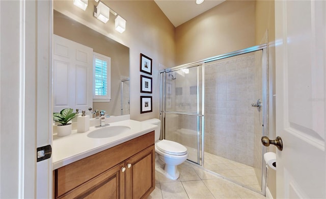 bathroom featuring tile patterned flooring, a shower with door, vanity, and toilet