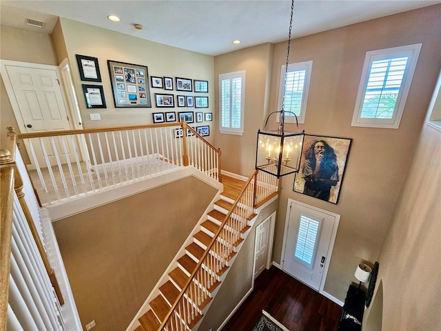 entrance foyer with plenty of natural light, dark hardwood / wood-style floors, and an inviting chandelier