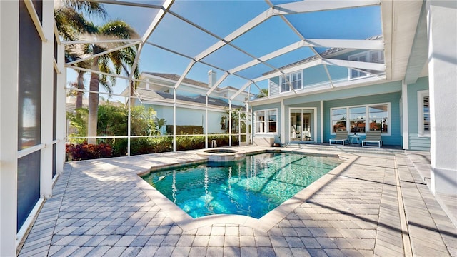 view of pool featuring an in ground hot tub, glass enclosure, and a patio area