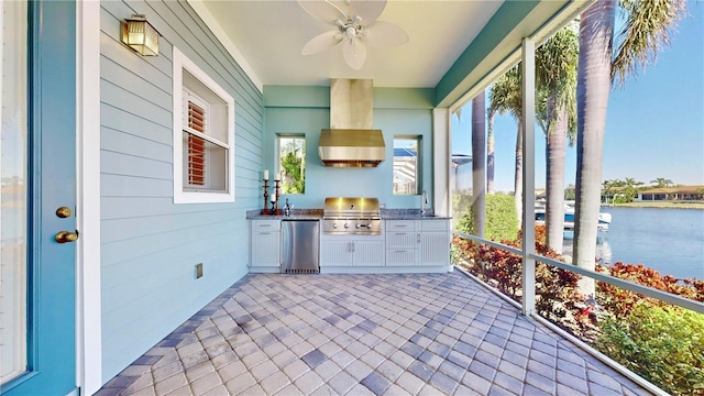 unfurnished sunroom featuring ceiling fan and a water view