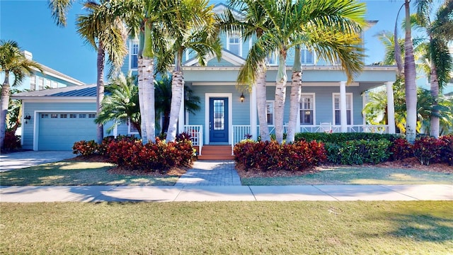 view of front of property featuring a porch, a front yard, and a garage