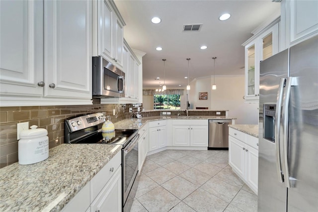 kitchen featuring light tile patterned floors, appliances with stainless steel finishes, white cabinets, and hanging light fixtures