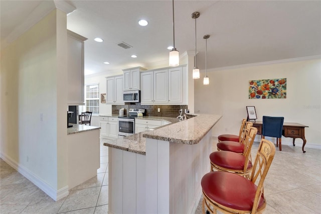 kitchen with white cabinets, decorative light fixtures, stainless steel appliances, kitchen peninsula, and a breakfast bar area