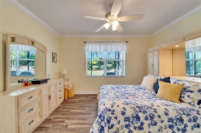 bedroom with ceiling fan, light hardwood / wood-style floors, and ornamental molding