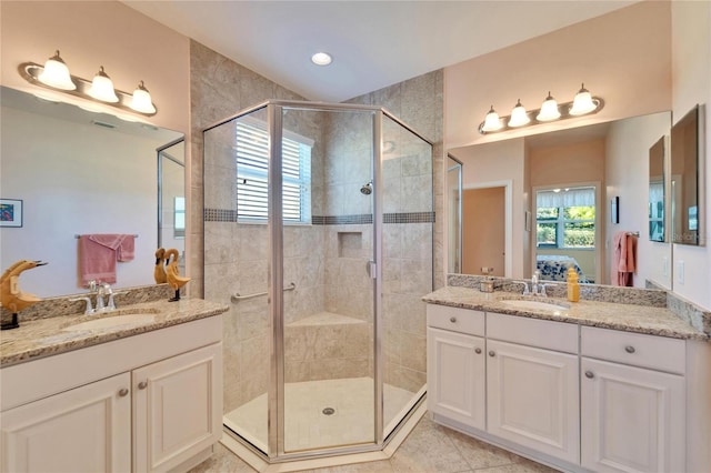 bathroom with a shower with shower door, vanity, and tile patterned flooring