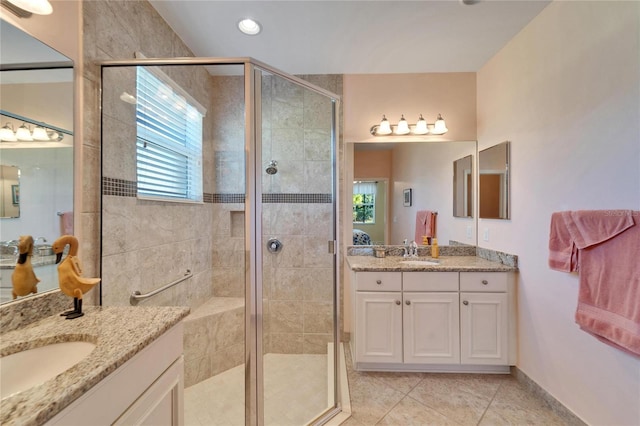 bathroom featuring walk in shower, vanity, and tile patterned flooring