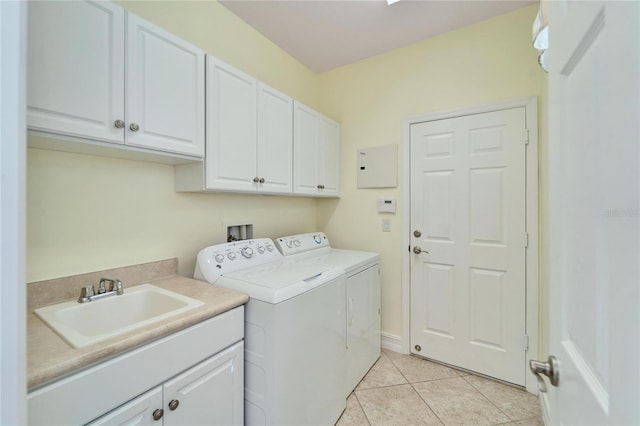 washroom featuring light tile patterned floors, cabinets, washer and dryer, and sink