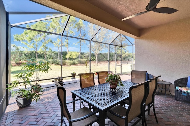 view of patio with ceiling fan and glass enclosure