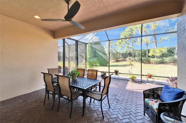 view of patio with ceiling fan and glass enclosure