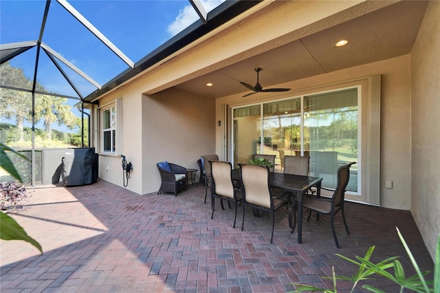 view of patio / terrace featuring ceiling fan and glass enclosure