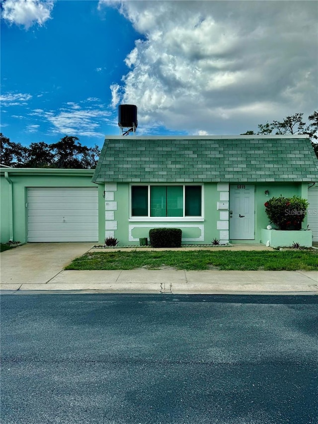 ranch-style house featuring a garage and cooling unit