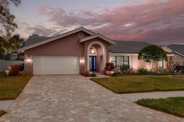 view of front of home featuring a garage and a lawn