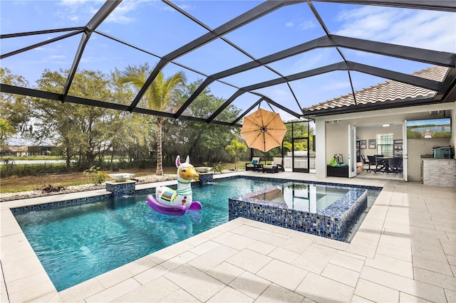 view of pool featuring a lanai, area for grilling, an in ground hot tub, and a patio area