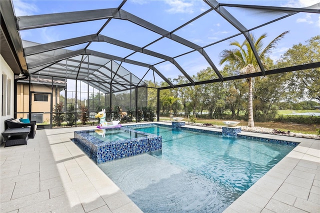 view of pool with a lanai, a patio area, pool water feature, and an in ground hot tub