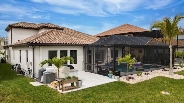 back of house featuring a lanai, a yard, and central air condition unit