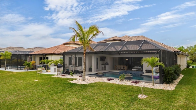 back of house featuring a yard, glass enclosure, and a patio area