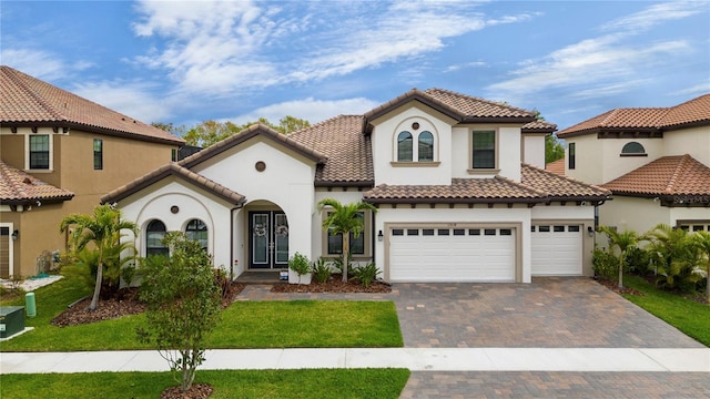 mediterranean / spanish-style house featuring a front yard and a garage