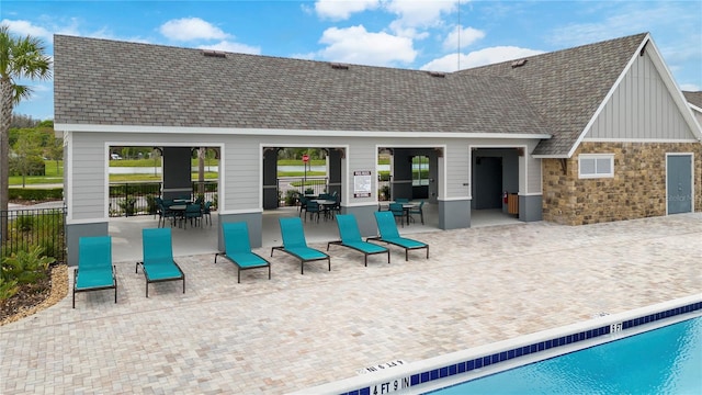 rear view of property with a community pool and a patio