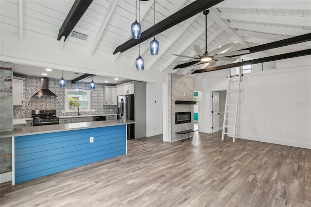 kitchen with wall chimney range hood, white cabinetry, hanging light fixtures, and stainless steel electric range oven