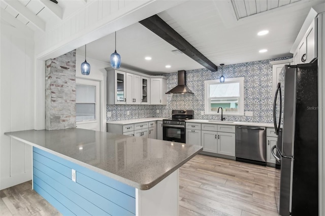 kitchen featuring wall chimney range hood, stainless steel appliances, beam ceiling, and kitchen peninsula